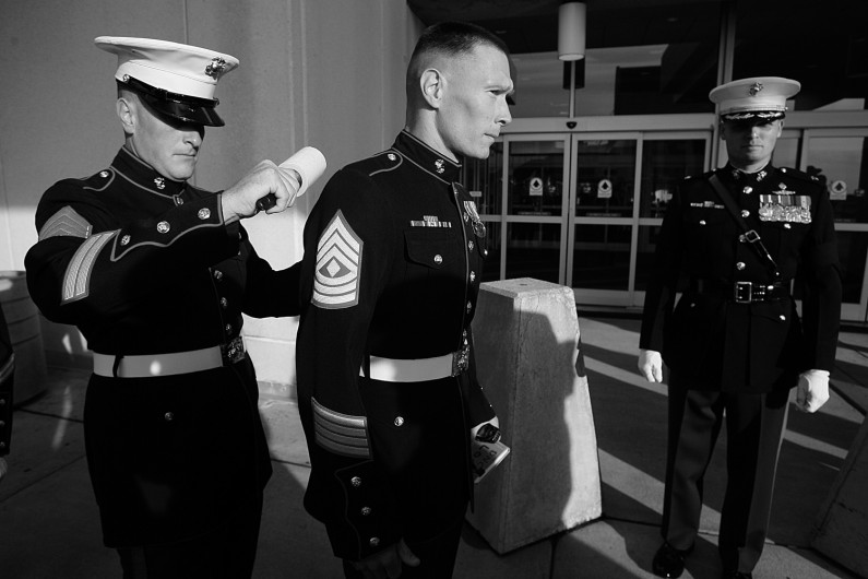 No part of the Marine dress blue uniforms goes uninspected and at the airport before the arrival of Lueken's body, Staff Sgt. Kevin Bruce, center, used a lint roller on the back of 1st Sgt. Troy Euclide.