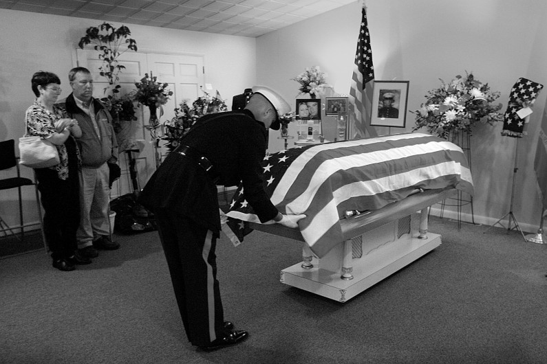 Melinda and Glenn "Jake" Lueken, of Dubois, watched as Maj. Randall Hoffman untucked the flag on the casket of their son, Eric.