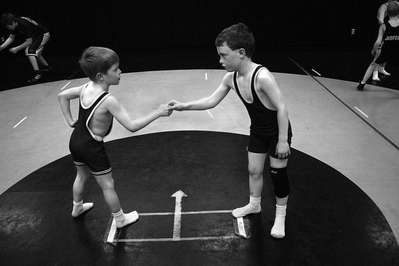 Second-graders Caleb Williams, left, and Brayden Betz shook hands before wrestling in practice. Meeting at the center of the mat and shaking hands is one of the first things young wrestlers learn in the Jasper Pee-Wee Wrestling League.