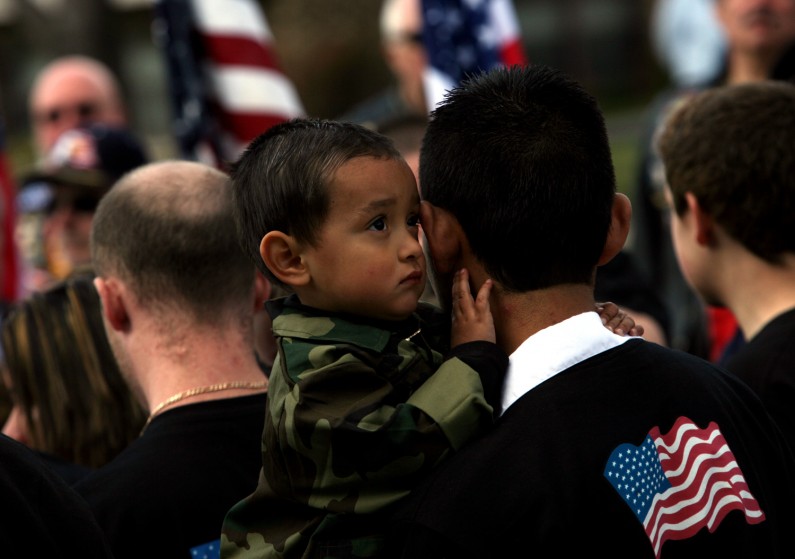 Daniel Serrato, 2, clings to his father, Rafael, as family and friends of fallen Illinois National Guard Sgt. Christopher Abeyta, hug outside Hickey Memorial Chapel in Midlothian.